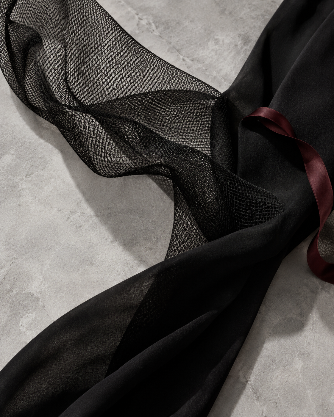 Black mesh and soft fabric with a burgundy ribbon